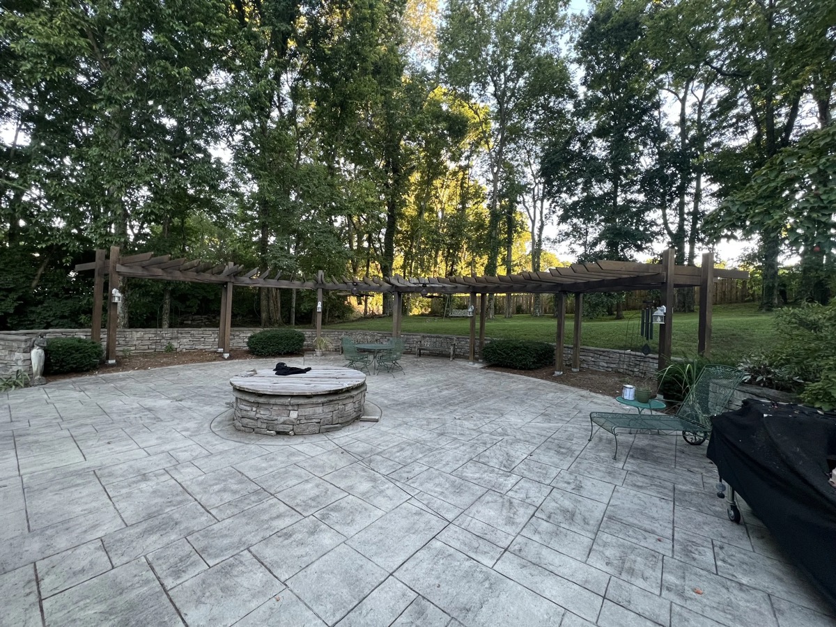 Stamped concrete patio with double pergola and stone fire pit built by Henning Construction in Middle Tennessee